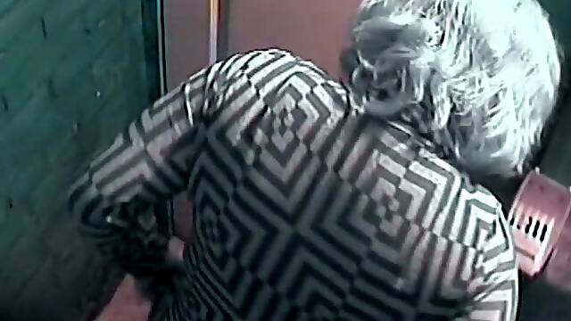 Mature white lady with blue dyed hair filmed in the toilet room